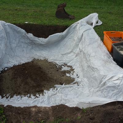 tarp in pit with material, clay unsoaked (ugh)