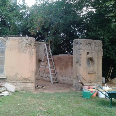 Das leicht angeregnete Gartenhaus, mit vielen Übungs-Lehmputzstellen